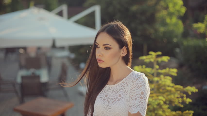Sexy Brunette With Long Dark Hair Sitting On Stone In The Garden Under Soft Light Sexy Brunette With Long Dark Hair Sitting On Stone In The Garden Under Soft Light