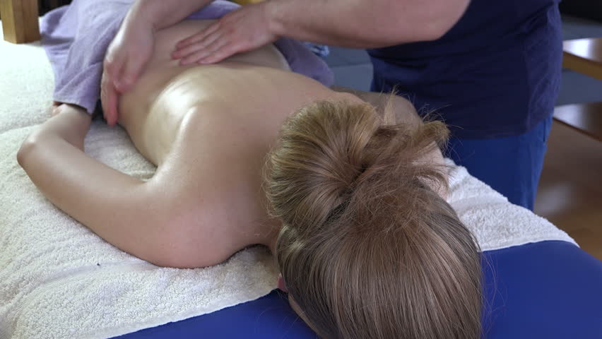 Masseur Man Hands Massage Female Client Woman Back On Portable Table At Client Home Tired Businesswoman Housewife Enjoy Releasing Back Massage Masseur Man Hands Massage Female Client Woman Back On Portable Table At Client Home Tired Businesswoman Housewife Enjoy Releasing Back Massage