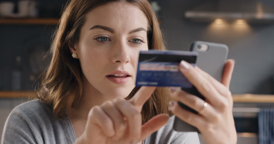 Beautiful woman online banking using smartphone shopping online with credit card at home lifestyle