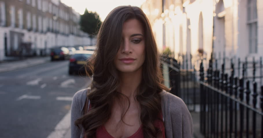 Beautiful woman using smart phone technology app walking through city streets living urban happy lifestyle