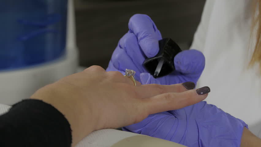 Beautician Artist Performing Nail Polish To Young At Beauty Hands Of Young Woman During Manicure Beautician Artist Polishing Nails Wearing Protective Gloves