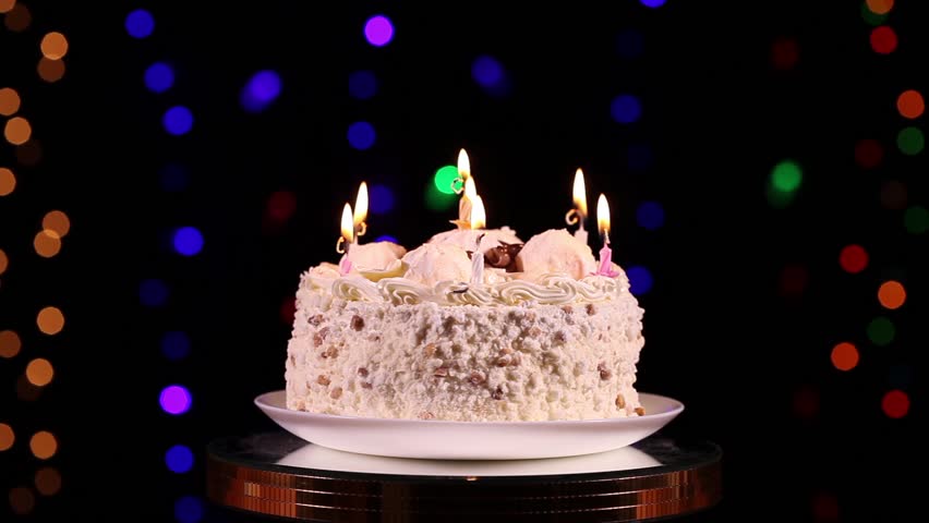 Happy Birthday Cake With Burning Candles In Front Of Black 