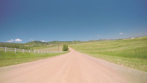 Car driving on rural dirt road in South Denver, near Chatfield State Park.-POV point of view.