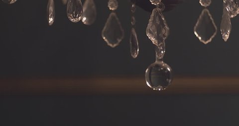 Close Up On A Crystal Chandelier Swaying Back And Forth In A Creepy Mansion Foyer Slow Motion