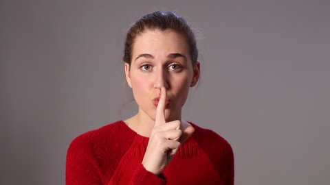 Junior Taboo Sex Porn - Sad beautiful young woman making the sign of silence, taboo or discretion,  keeping lips sealed for fear, grey background