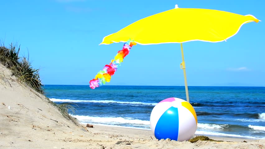 beach ball in ocean. beach ball and parasol on the sand - hd stock footage clip in ocean l