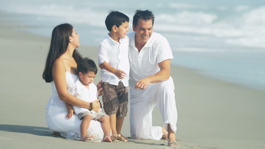 A Healthy Latin American Family Enjoying Relaxation On The Beach ...