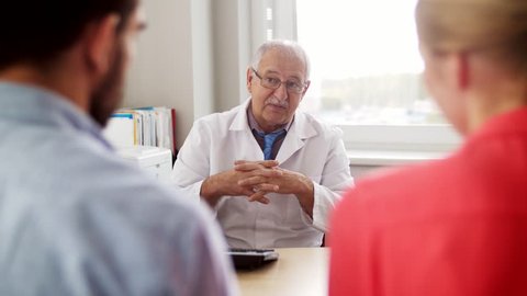 family planning, medicine and healthcare concept - couple visiting doctor at fertility clinic