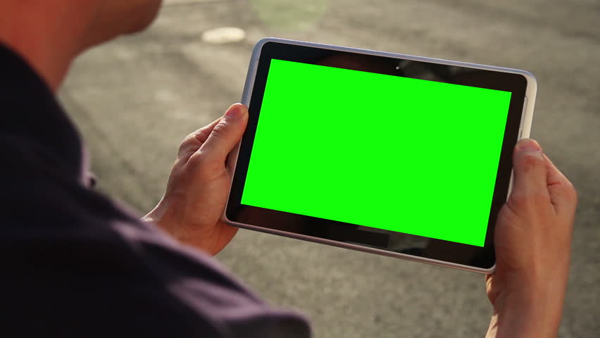 A man holds a blank tablet PC with a green screen for your own custom content.