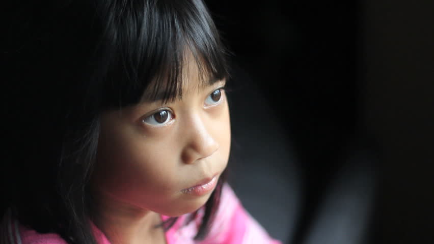 A Sad Lonely 8 Year Old Asian Girl Looks Towards The Camera After ...