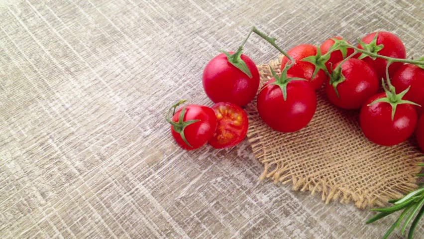Closeup Of Bunch Wet Tomatoes And Rosemary On Wooden Kitchen Table Closeup Of Bunch Wet Tomatoes And Rosemary On Wooden Kitchen Table