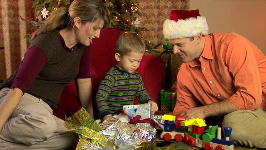 Mother Father And Son In Pajamas Opening Christmas Presents